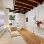 Узкая гостиная Millay House с диваном, деревянными балками и окнами в Вест-Виллидж