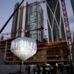 Панорама skyline Майами с подсвеченной инсталляцией JEM in the Sky над строящейся жилой башней